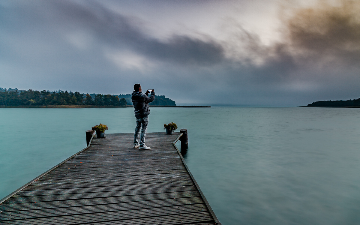 Fotograf Stefan Gerlach mit dem Smartphone am See