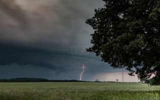 Gewitter auf dem Feld mit Blitz in der Ferne