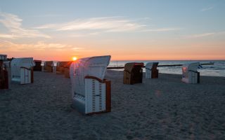 Strandkörbe im Sonnenaufgang an der Ostsee